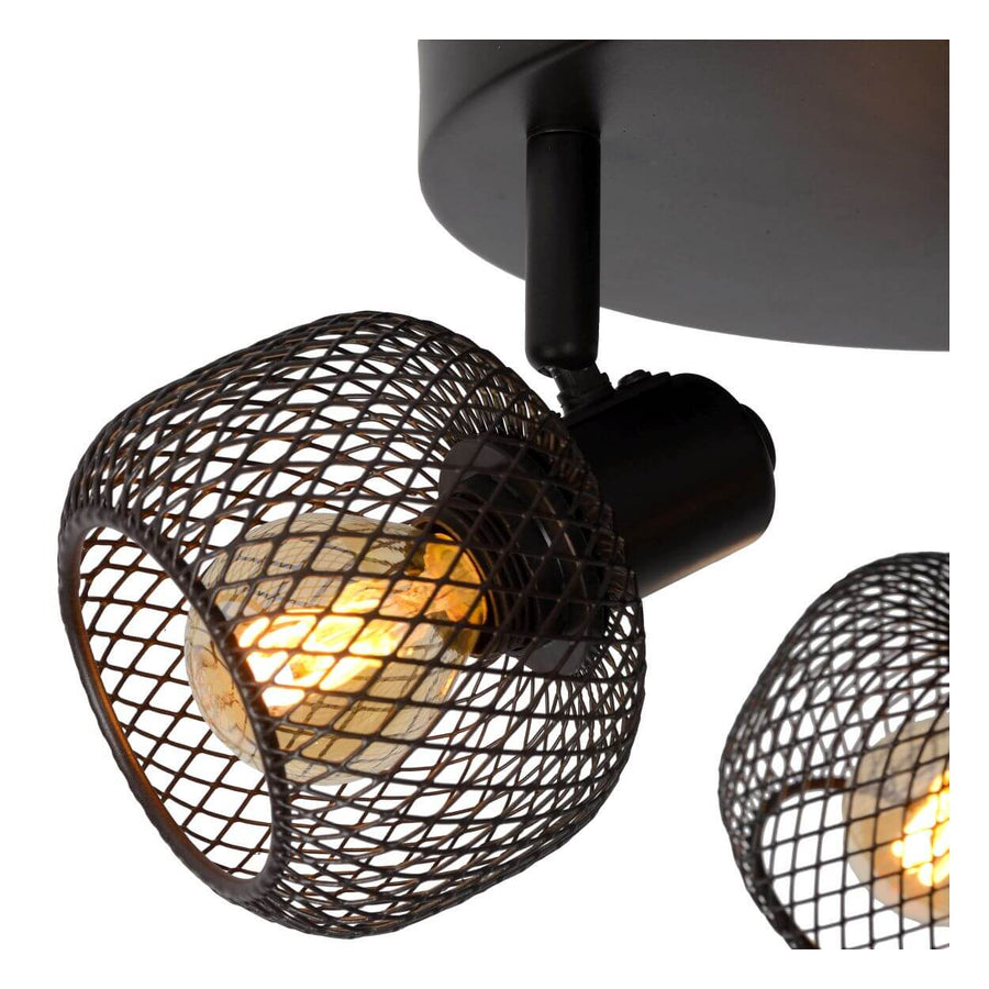 Gros plan sur la grille métallique et l'ampoule chaude du luminaire