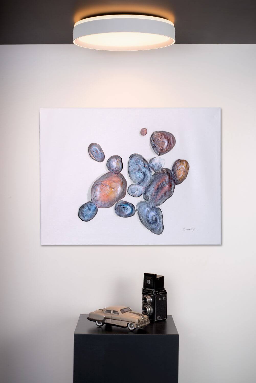Vue rapprochée du plafonnier blanc éclairé sur plafond sombre, décor de salon