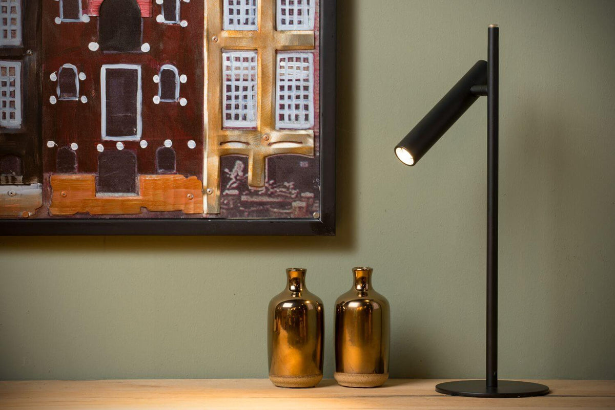 Vue rapprochée de la lampe noire et de deux vases dorés