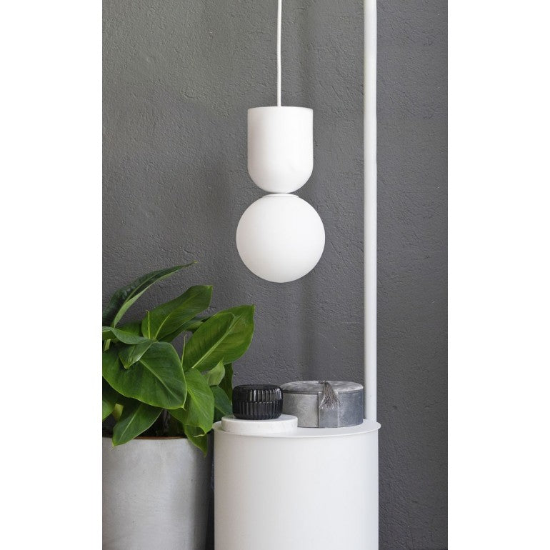 Mise en ambiance blanche de la suspension au-dessus d'un pot de plante verte.