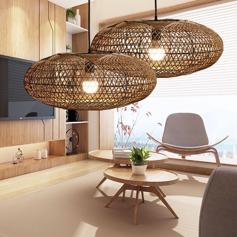 Paire de luminaires en rotin tressé suspendue au-dessus de tables basses en bois clair