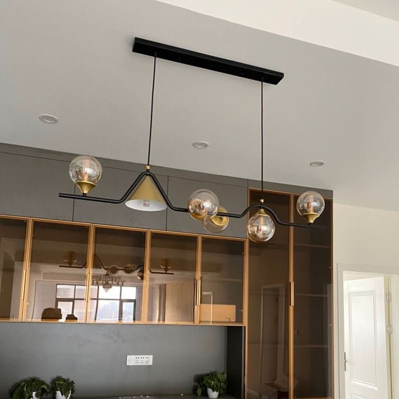 Installation au plafond, vue en contre-plongée, globes dorés devant des vitrines de cuisine
