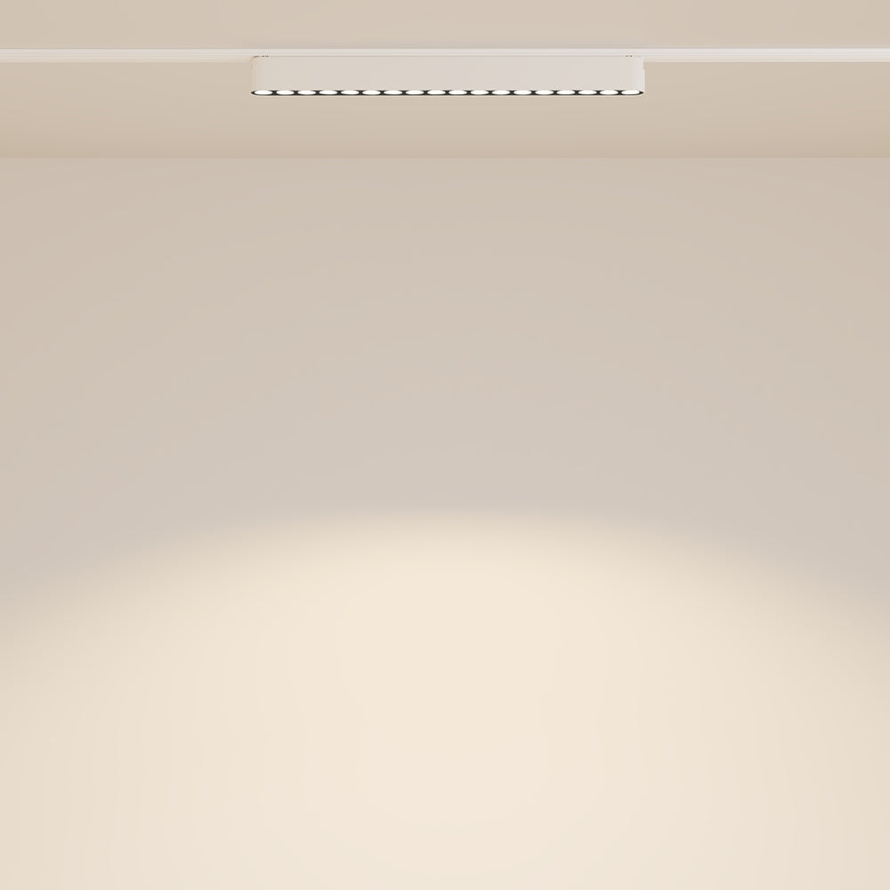 Mise en ambiance d'un rail lumineux au plafond éclairant un mur beige