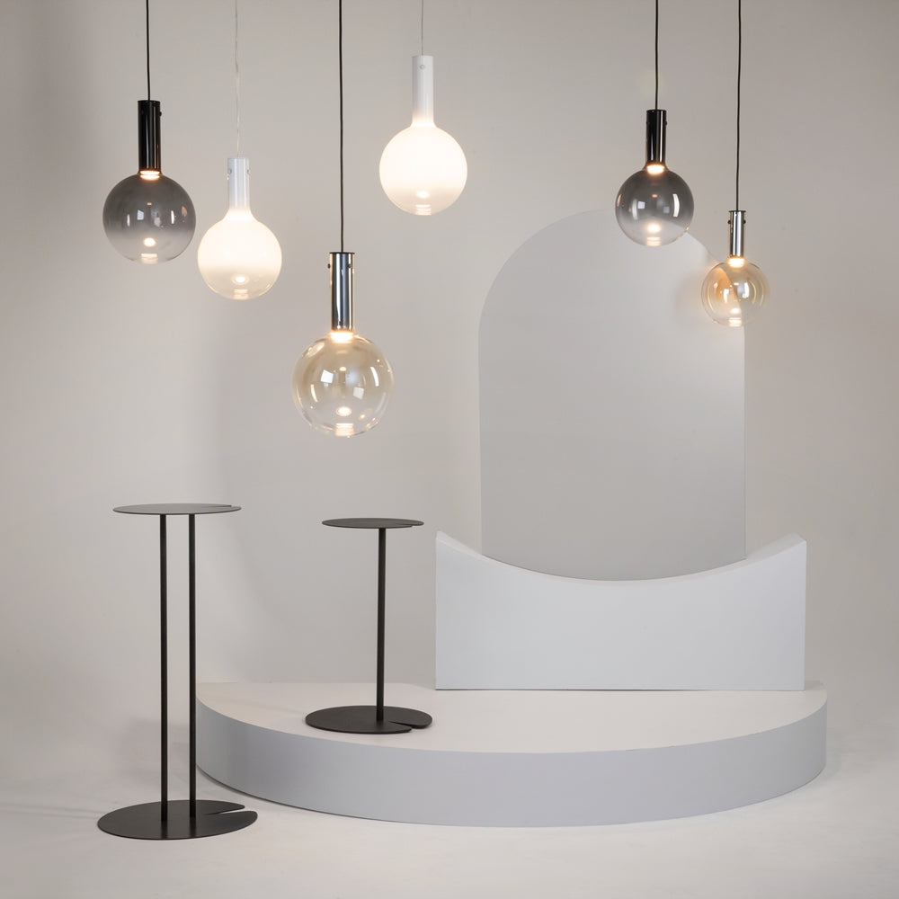 Ambiance avec plusieurs suspensions aux globes transparents, fumés ou blancs.