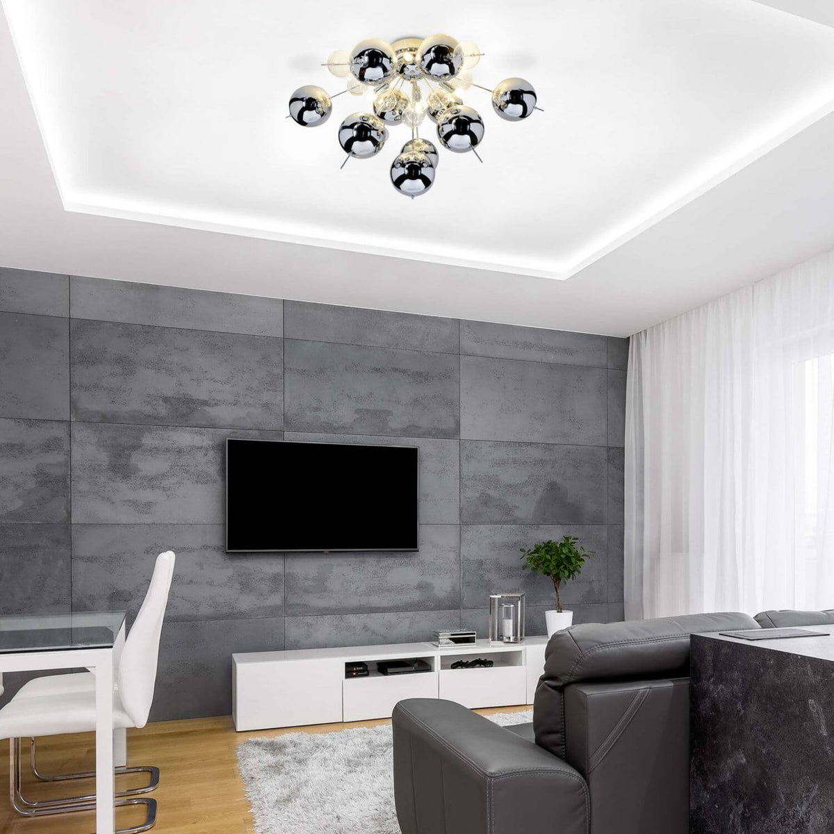 Plafonnier chromé vu de dessous dans un salon gris avec mur effet béton