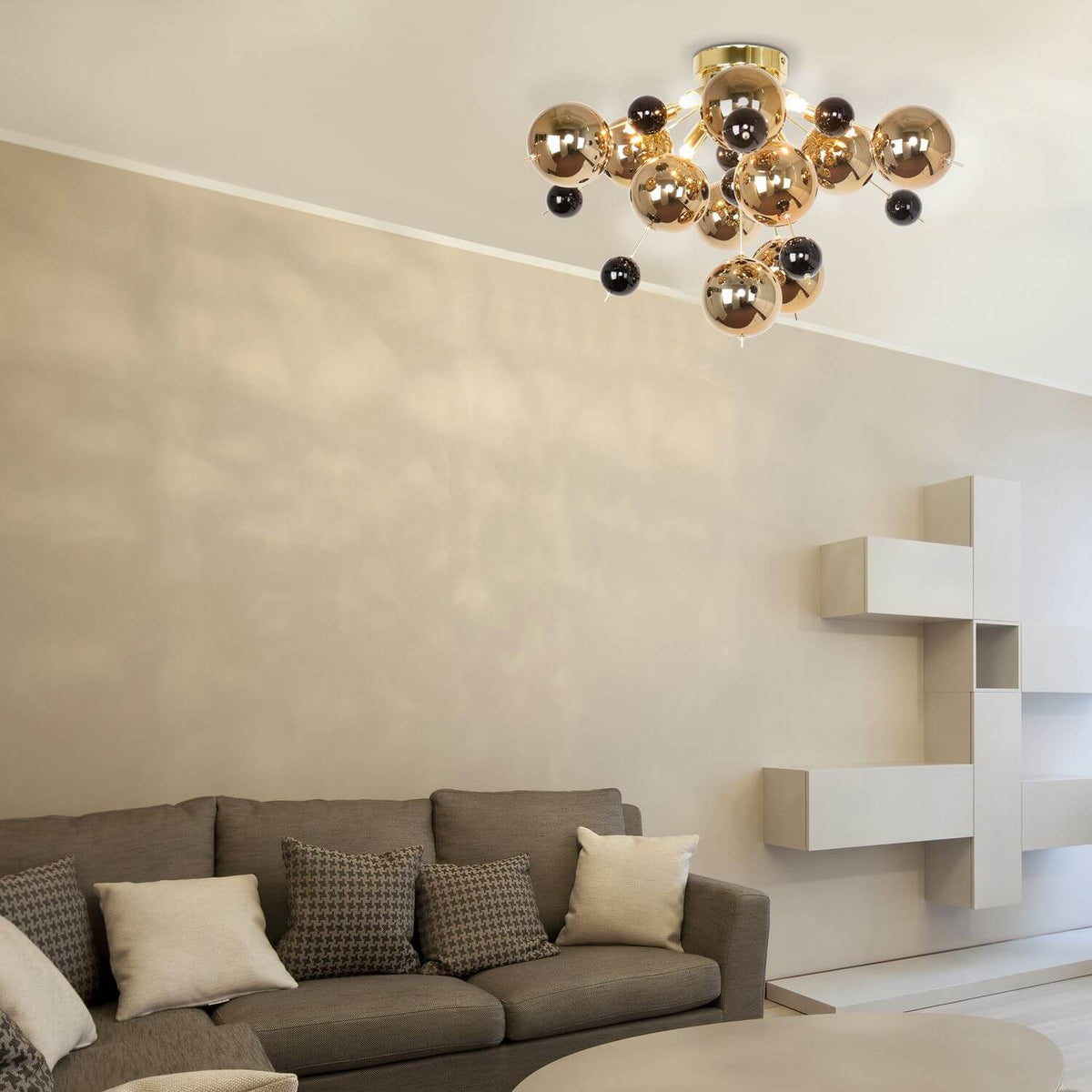 Vue rapprochée du plafonnier doré monté au plafond, avec sphères en verre noir et ambré.