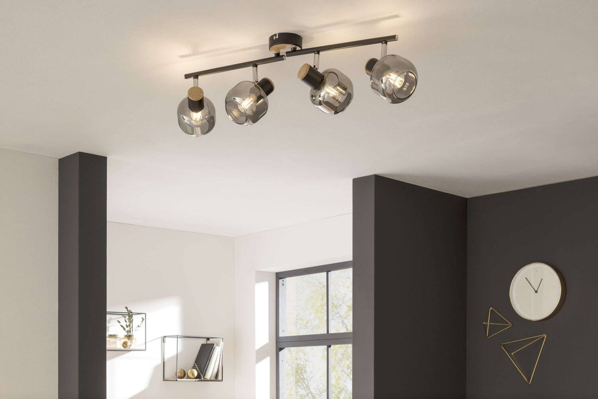 Plafonnier allumé fixé au plafond blanc, orientable, diffusant une lumière chaude