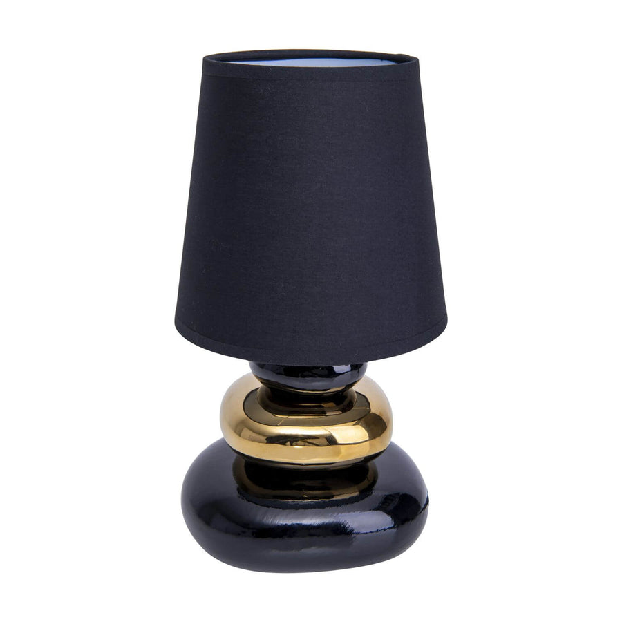 Vue de face d'une lampe à poser noire et dorée avec abat-jour en tissu