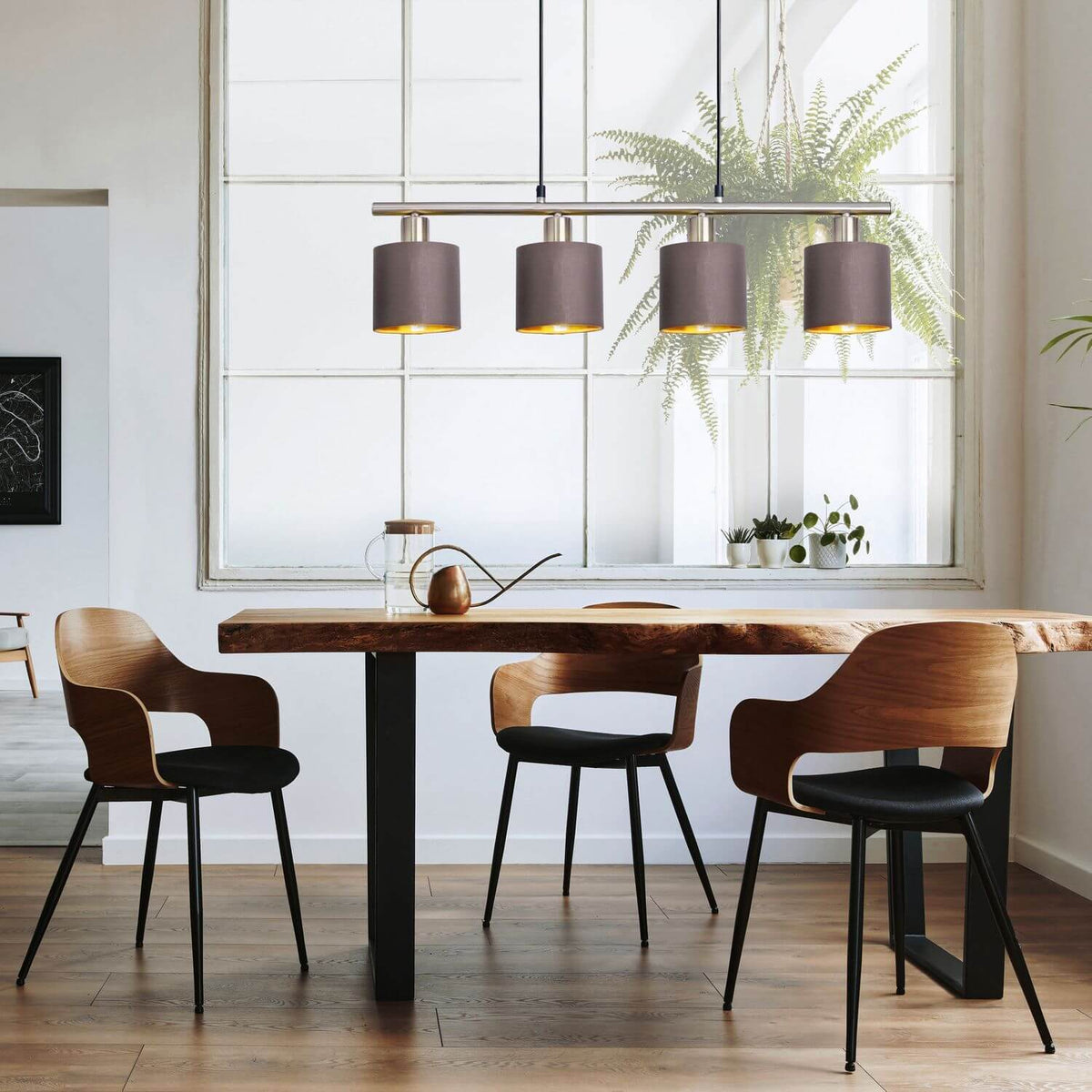 Luminaire suspendu éclairé au-dessus d'une table en bois massif dans une salle à manger lumineuse
