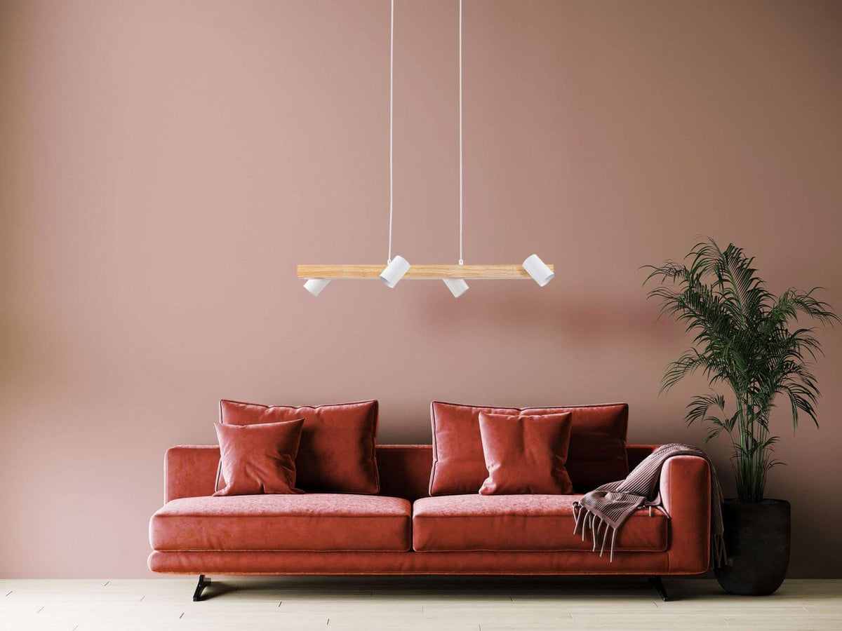Suspension blanche en bois suspendue au-dessus d'un canapé rose dans un salon.