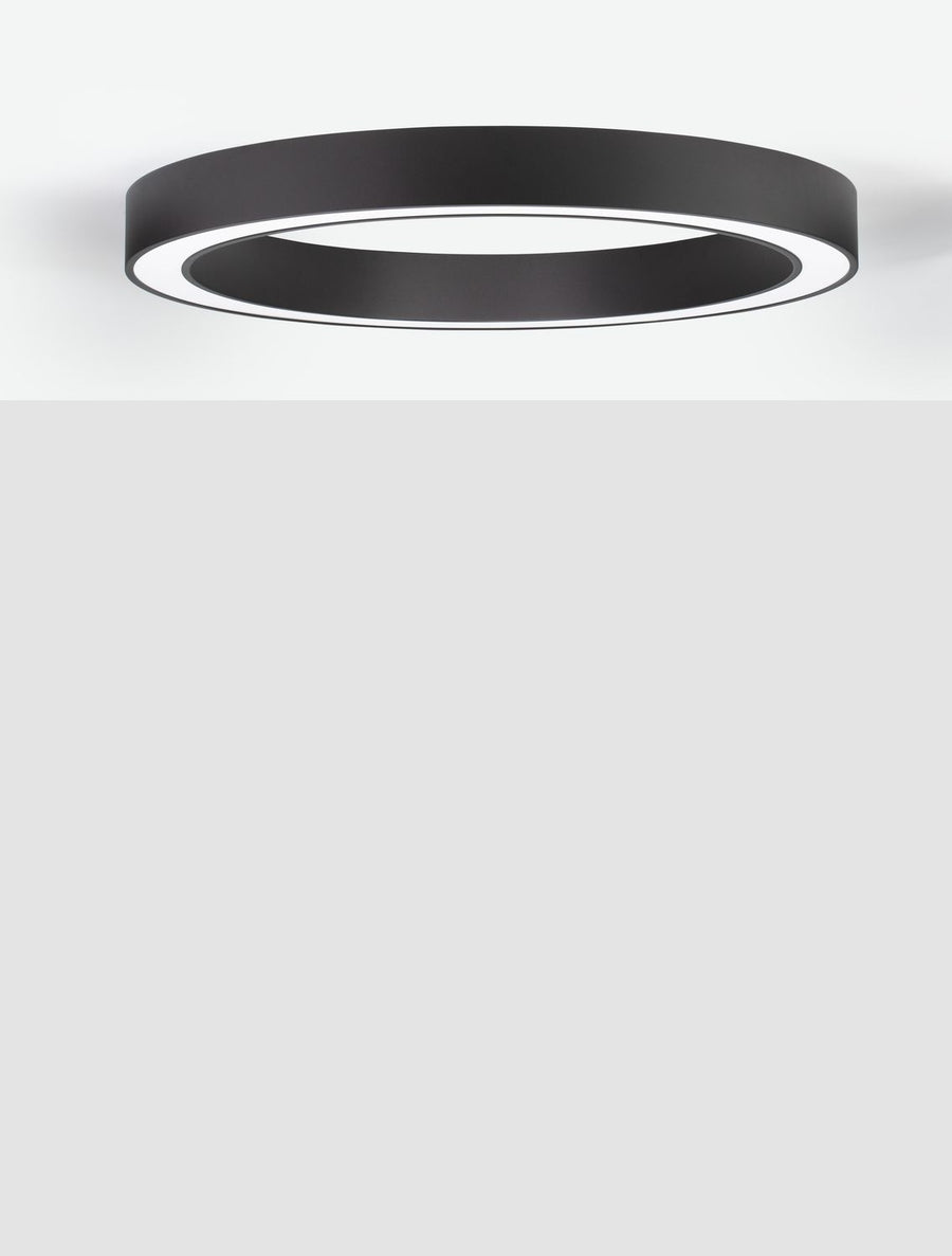 Plafonnier rond noir fixé au plafond blanc, vue en perspective légèrement inclinée
