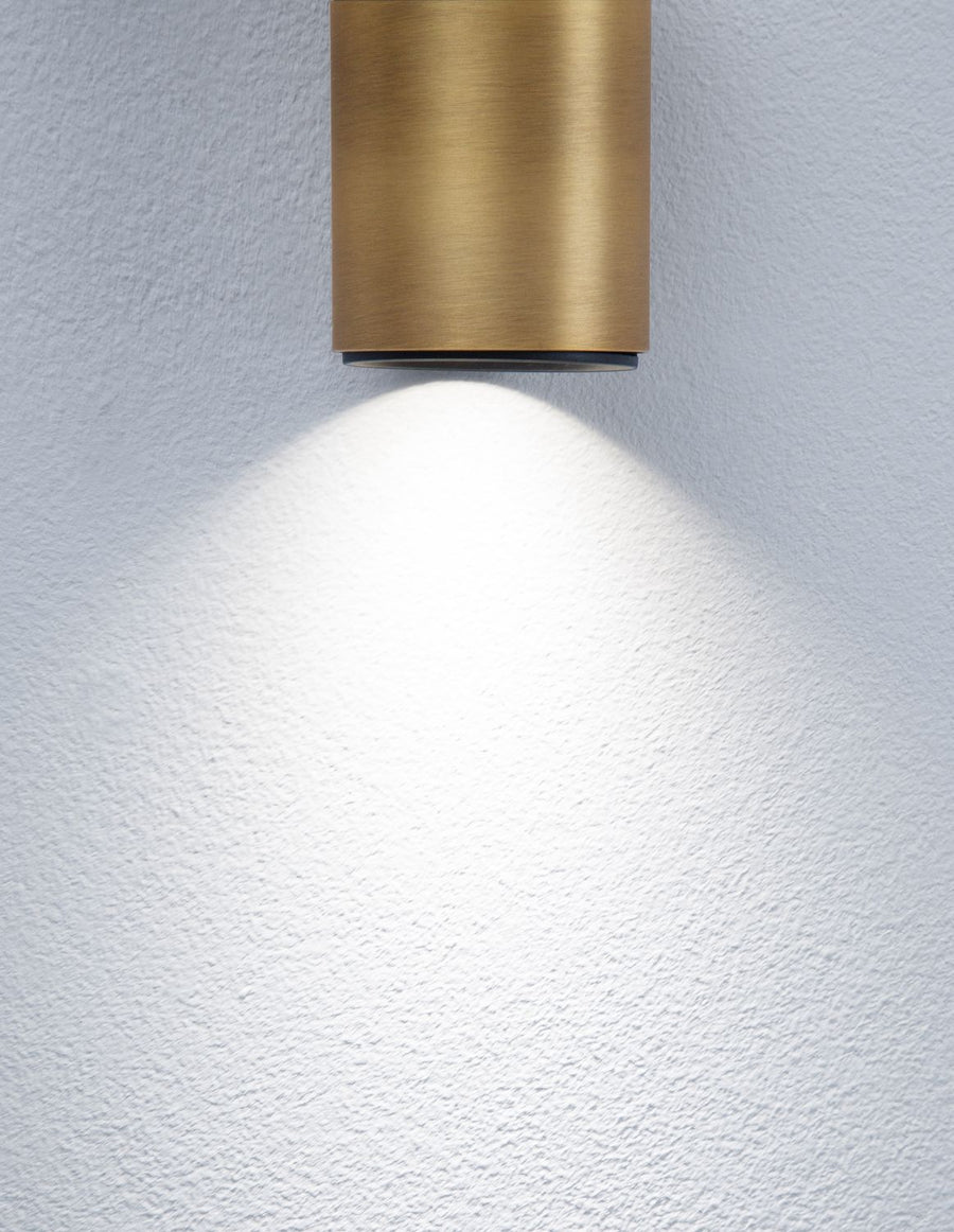 Détail du faisceau lumineux projeté sur un mur blanc par le spot doré