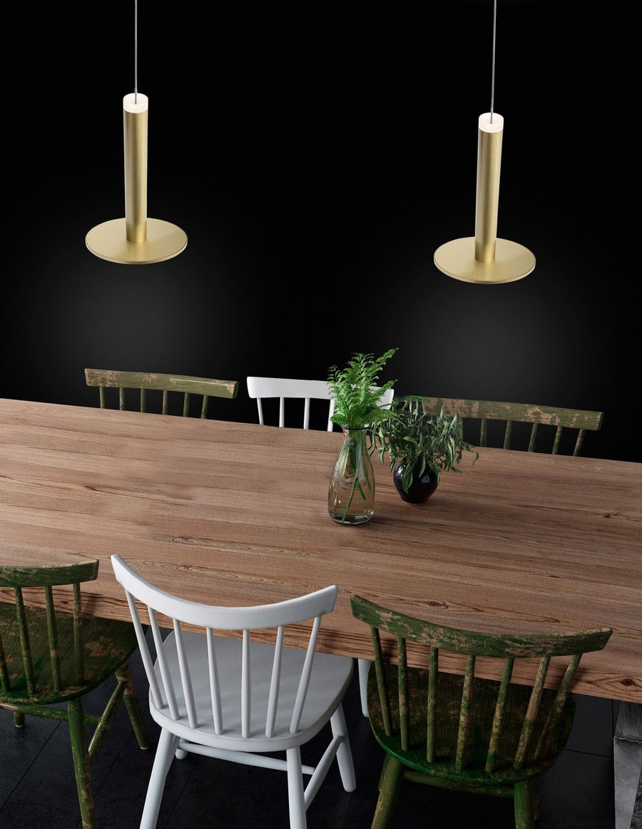Suspensions laiton au-dessus d'une longue table en bois et de chaises vertes patinées