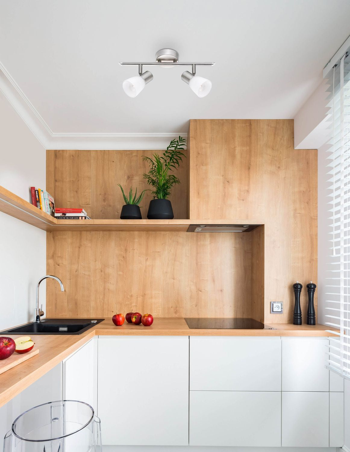 Mise en ambiance cuisine moderne, plafonnier allumé au-dessus d'un plan de travail.