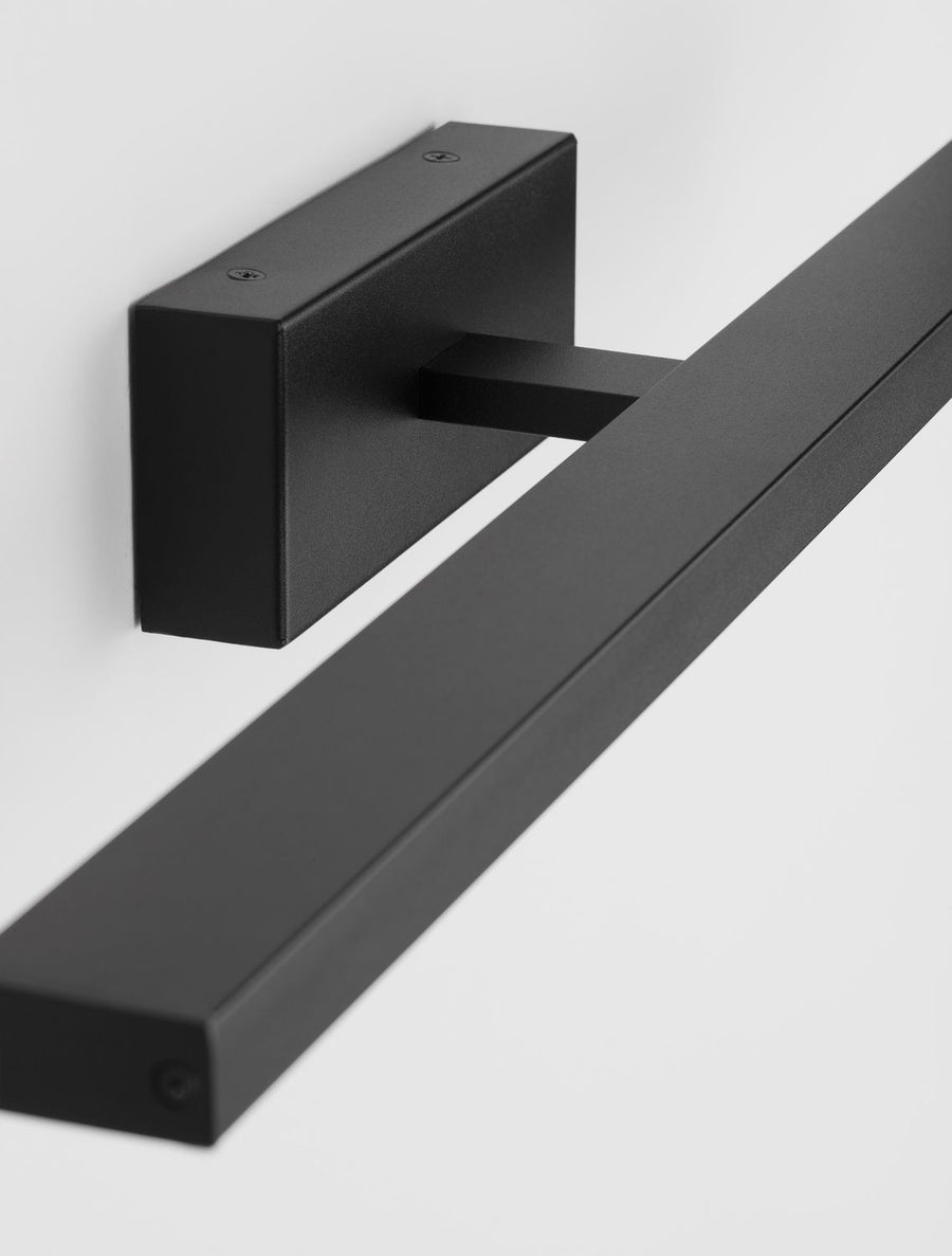 Gros plan sur la platine murale noire et l'emboîtement du profilé rectangulaire