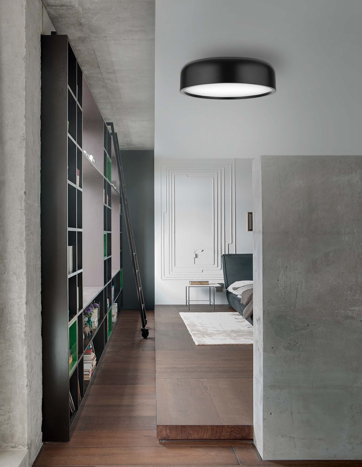 Plafonnier rond noir fixé au plafond d'un intérieur moderne en béton, vue d'ensemble