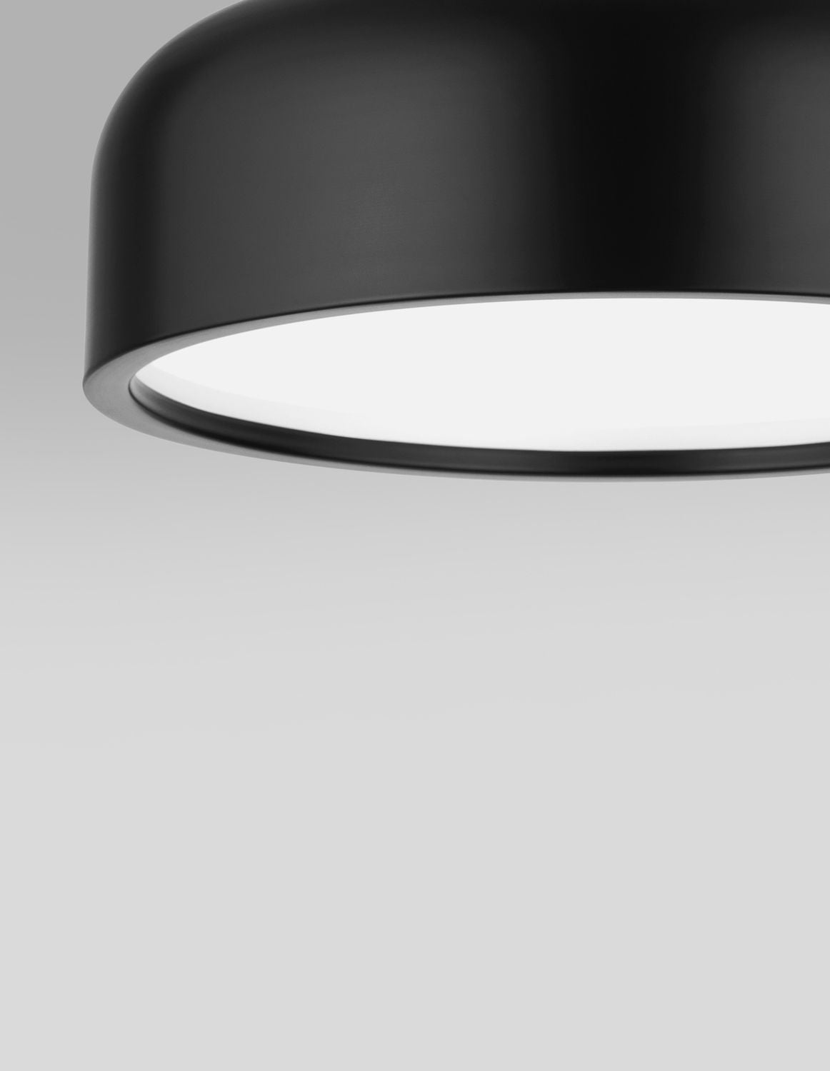 Détail rapproché du bord arrondi et de la finition mate noire du luminaire