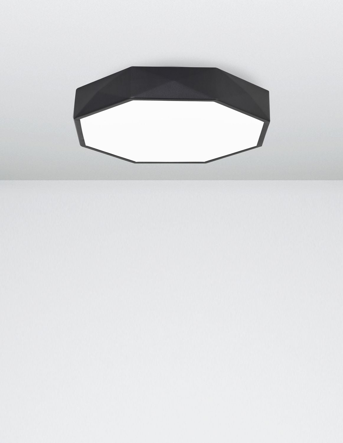 Vue rapprochée du plafonnier allumé éclairant un plafond blanc uni
