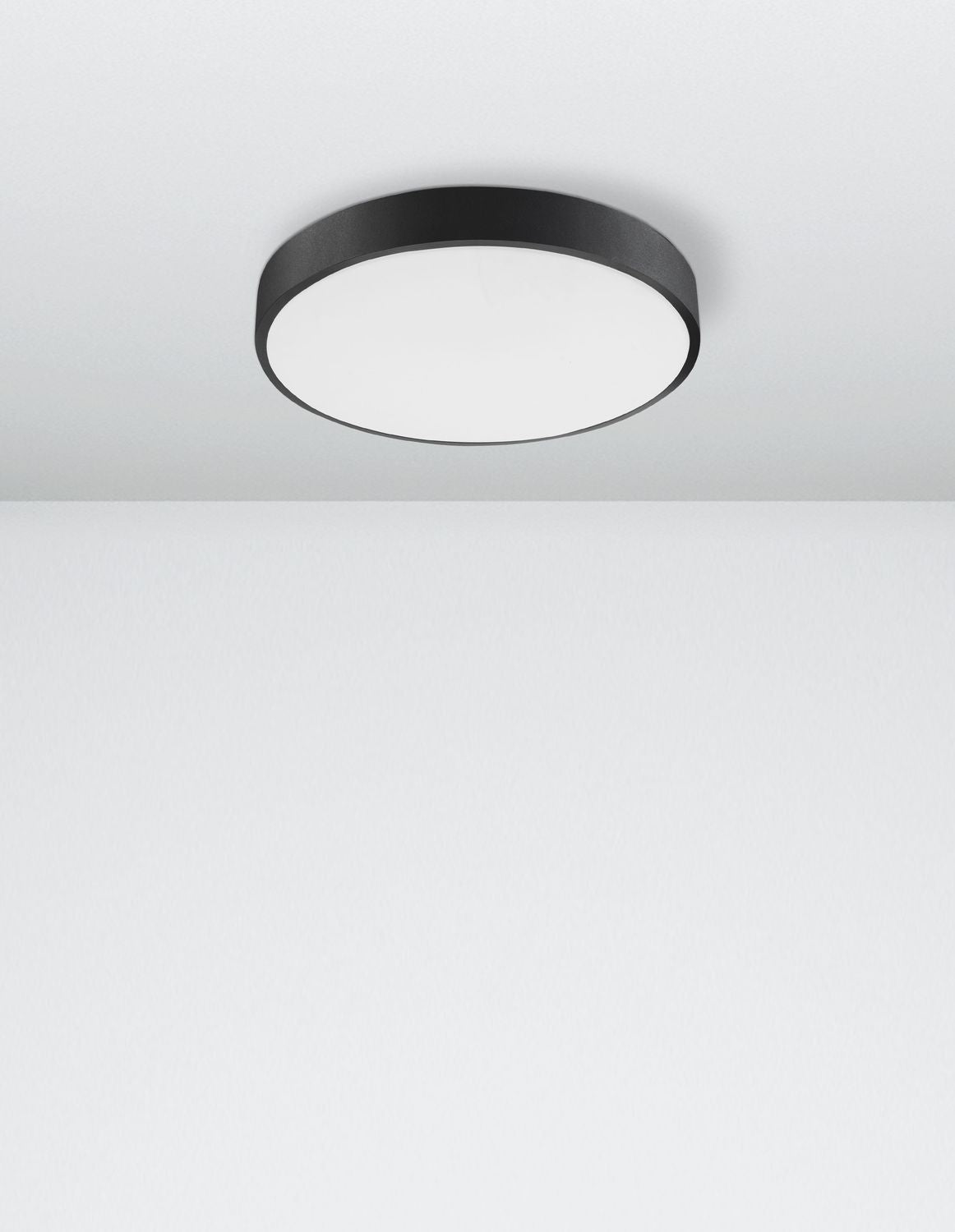 Vue en légère plongée du luminaire circulaire fixé au plafond d'une pièce claire