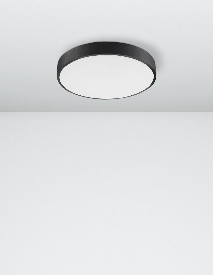 Vue en légère plongée du luminaire circulaire fixé au plafond d'une pièce claire