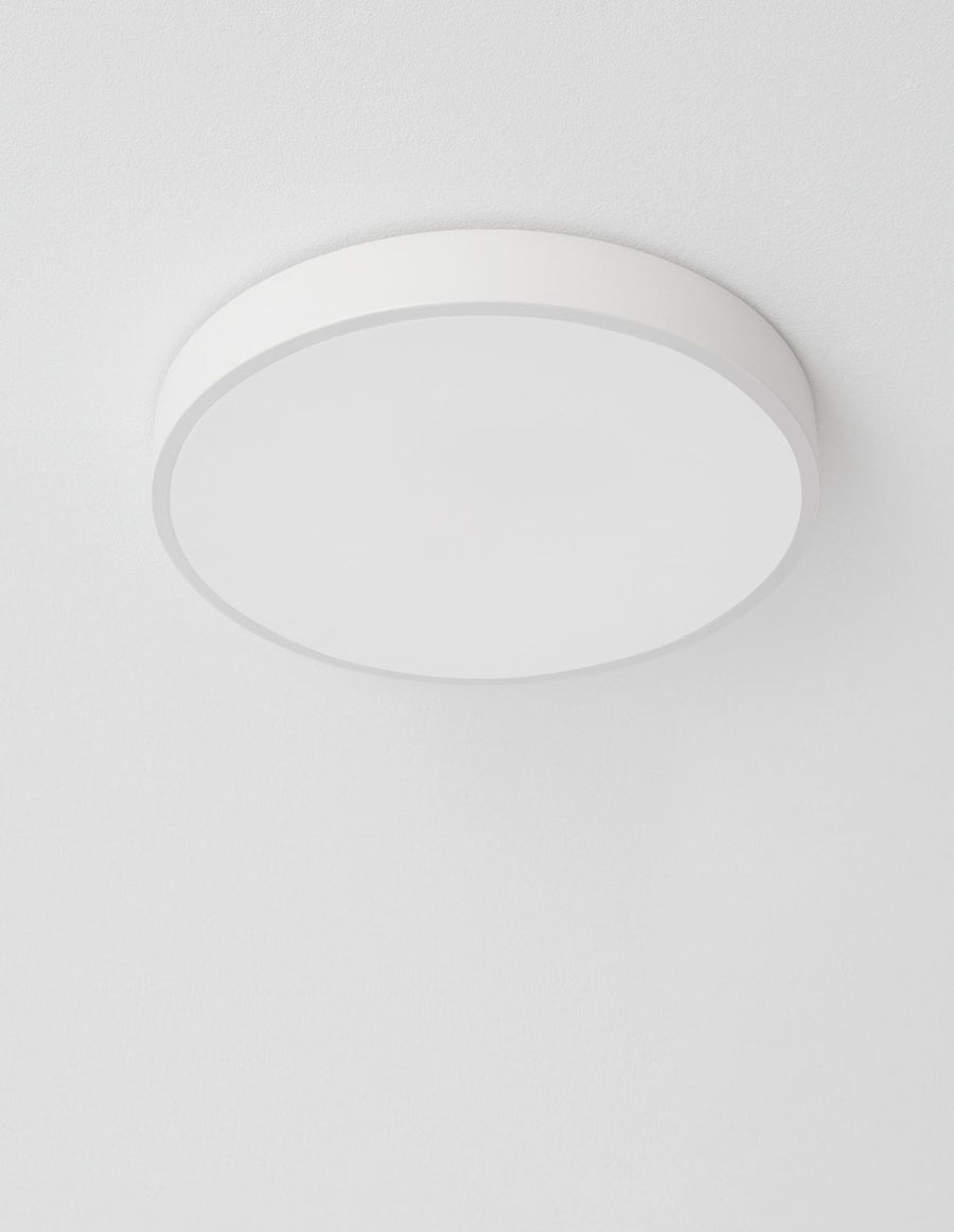 Plafonnier blanc vu de dessous, fixé au plafond, lumière éteinte, cadrage rapproché