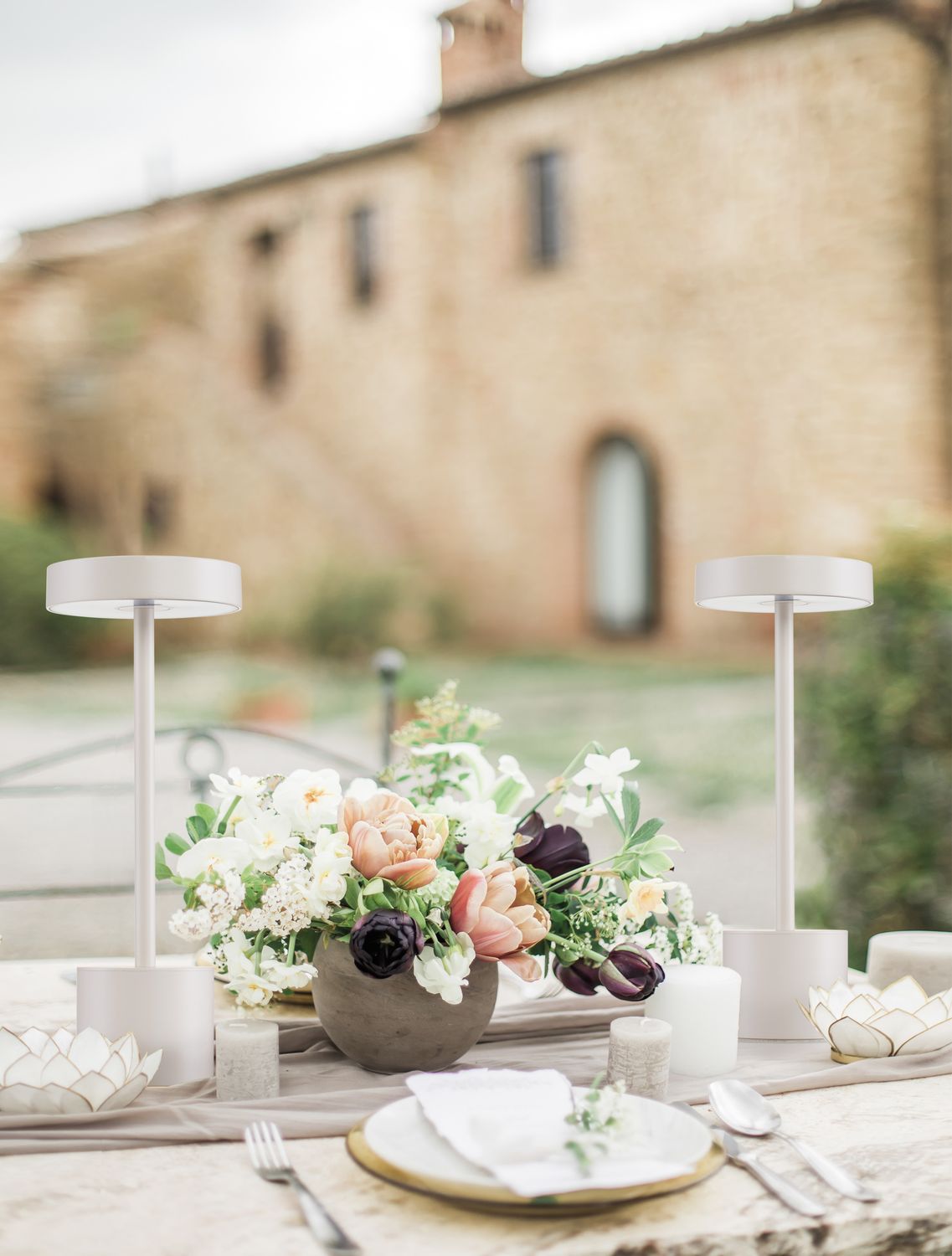 Mise en ambiance, deux lampes blanches posées sur une table décorée de fleurs