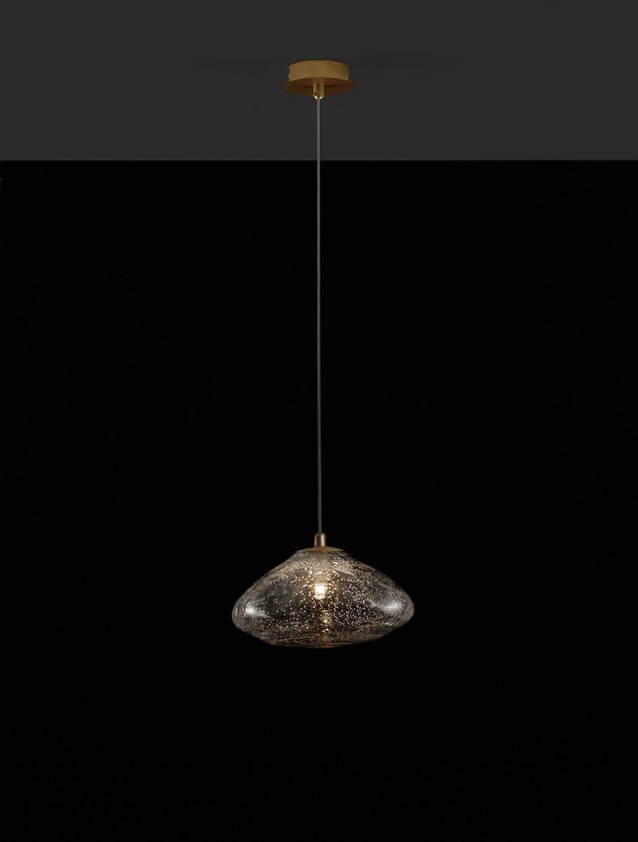Luminaire allumé sur fond noir, lumière chaude traversant le verre grenu.