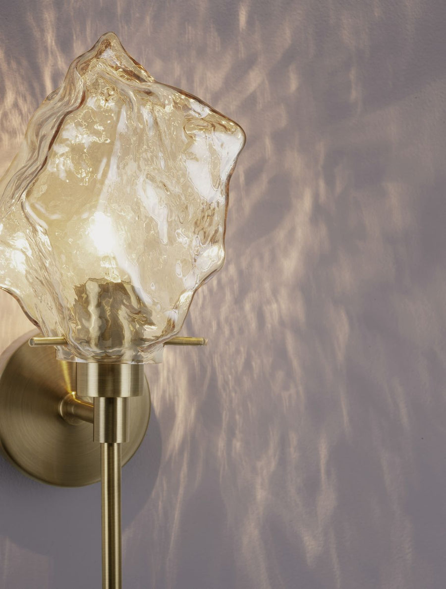 Détail du verre froissé diffusant une lumière chaude et ses reflets muraux