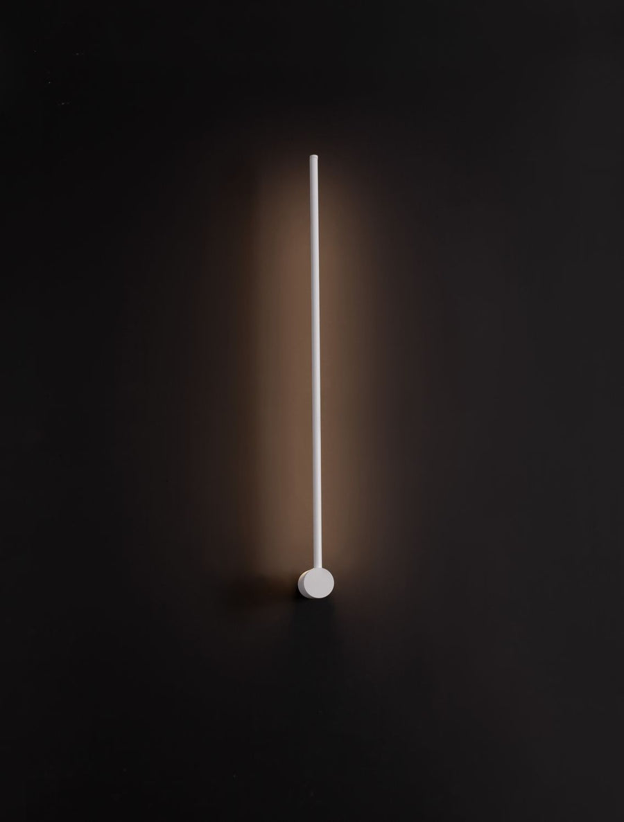 Luminaire allumé dans l'obscurité, halo lumineux diffus projeté sur le mur