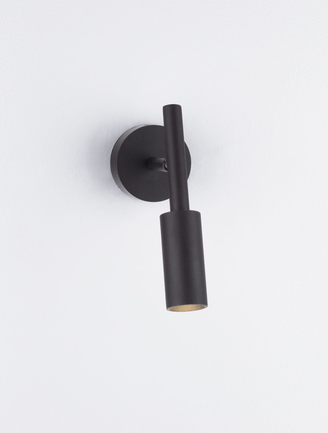 Détail du bas de l'applique noire laissant apparaître l'ampoule dorée à l'intérieur