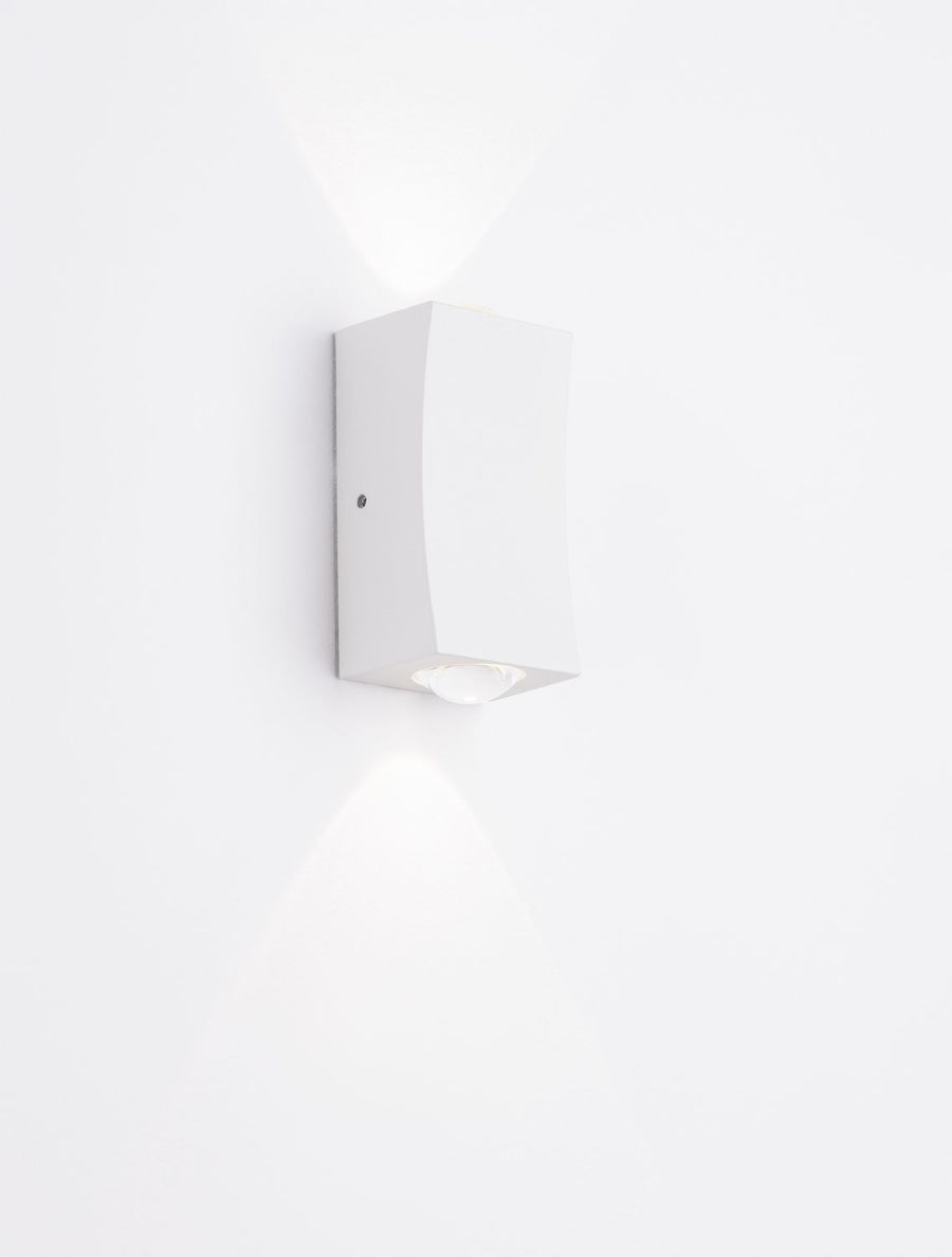Applique allumée sur un mur blanc, éclairage vers le haut et le bas, rendu lumineux