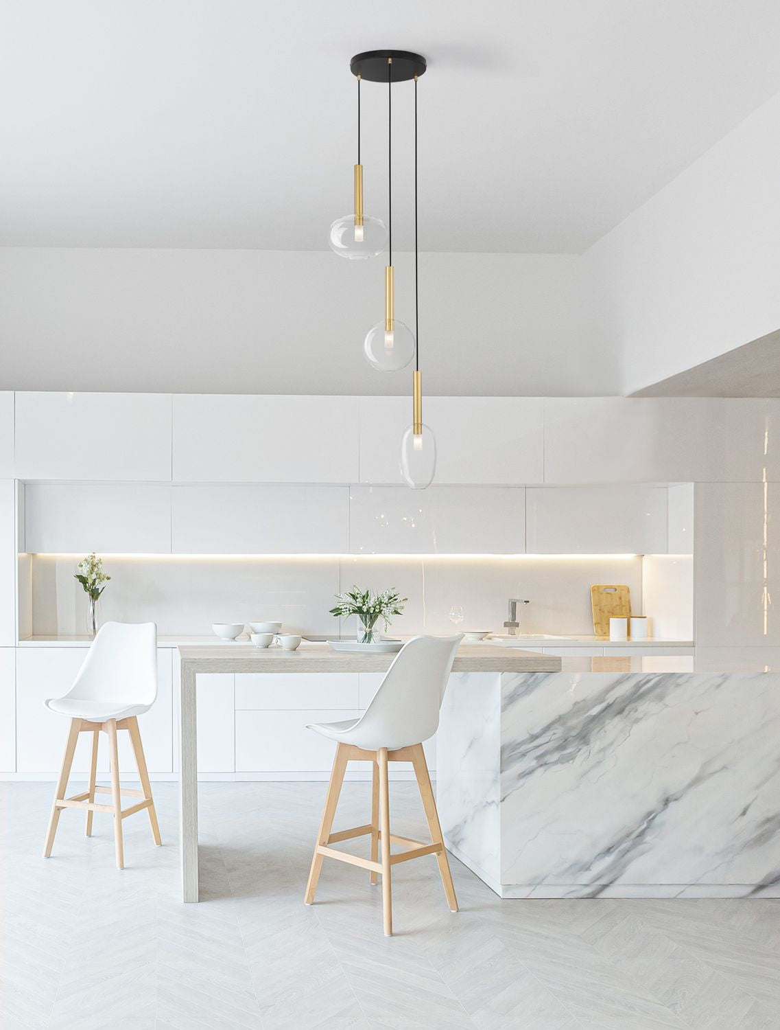 Suspension installée au-dessus d'un îlot de cuisine blanc et marbre, vue d'ambiance
