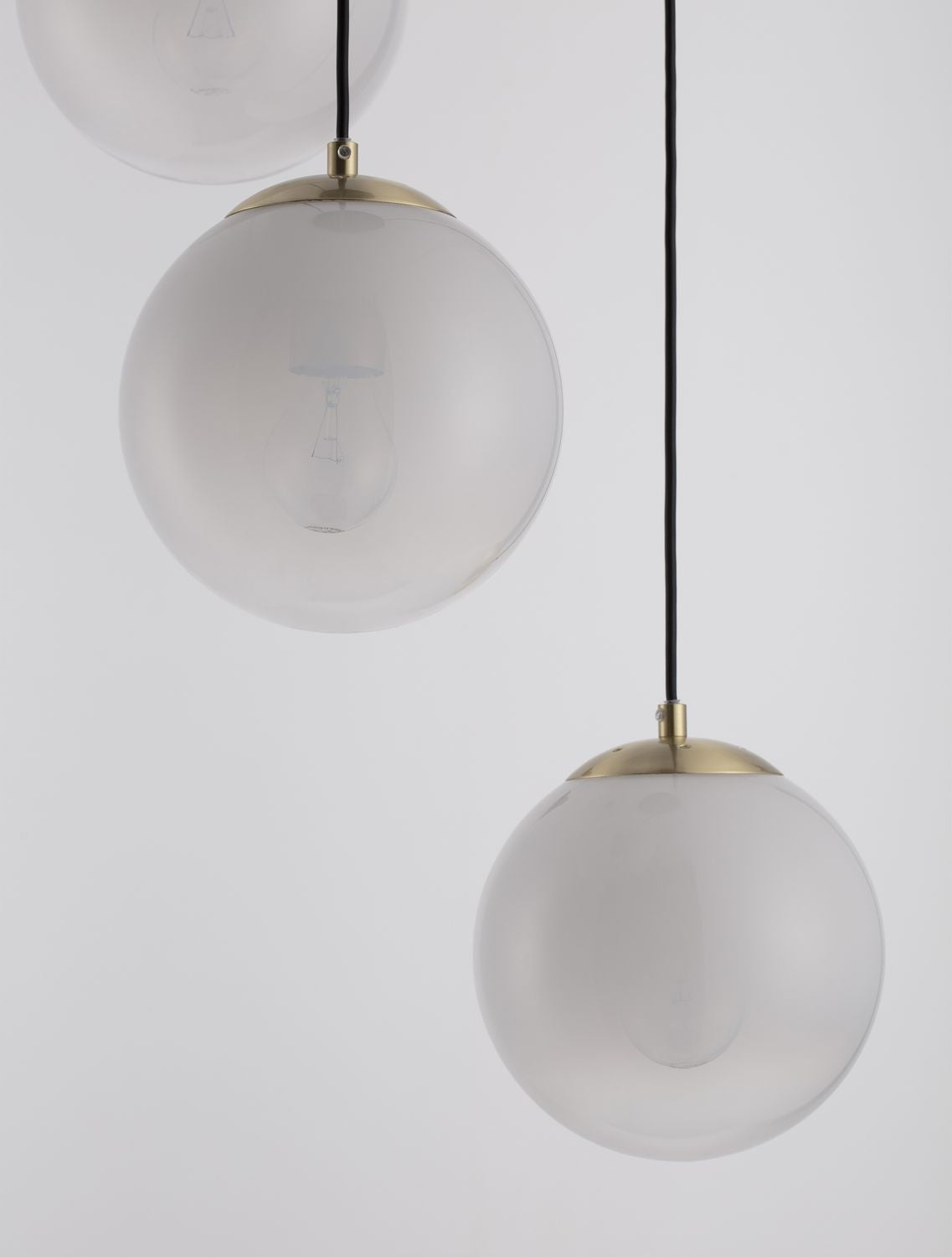 Gros plan sur les globes en verre dépoli et l'ampoule visible à l'intérieur