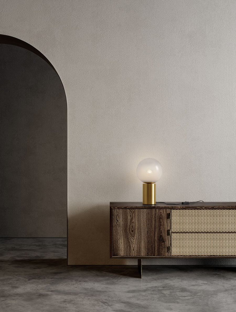 Lampe posée sur un meuble en bois cannage dans un intérieur beige