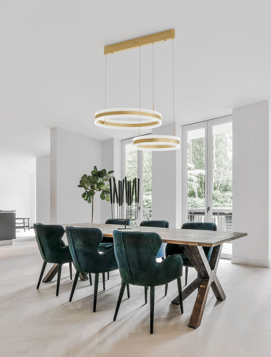 Suspension dorée à deux anneaux lumineux éclairant une salle à manger moderne