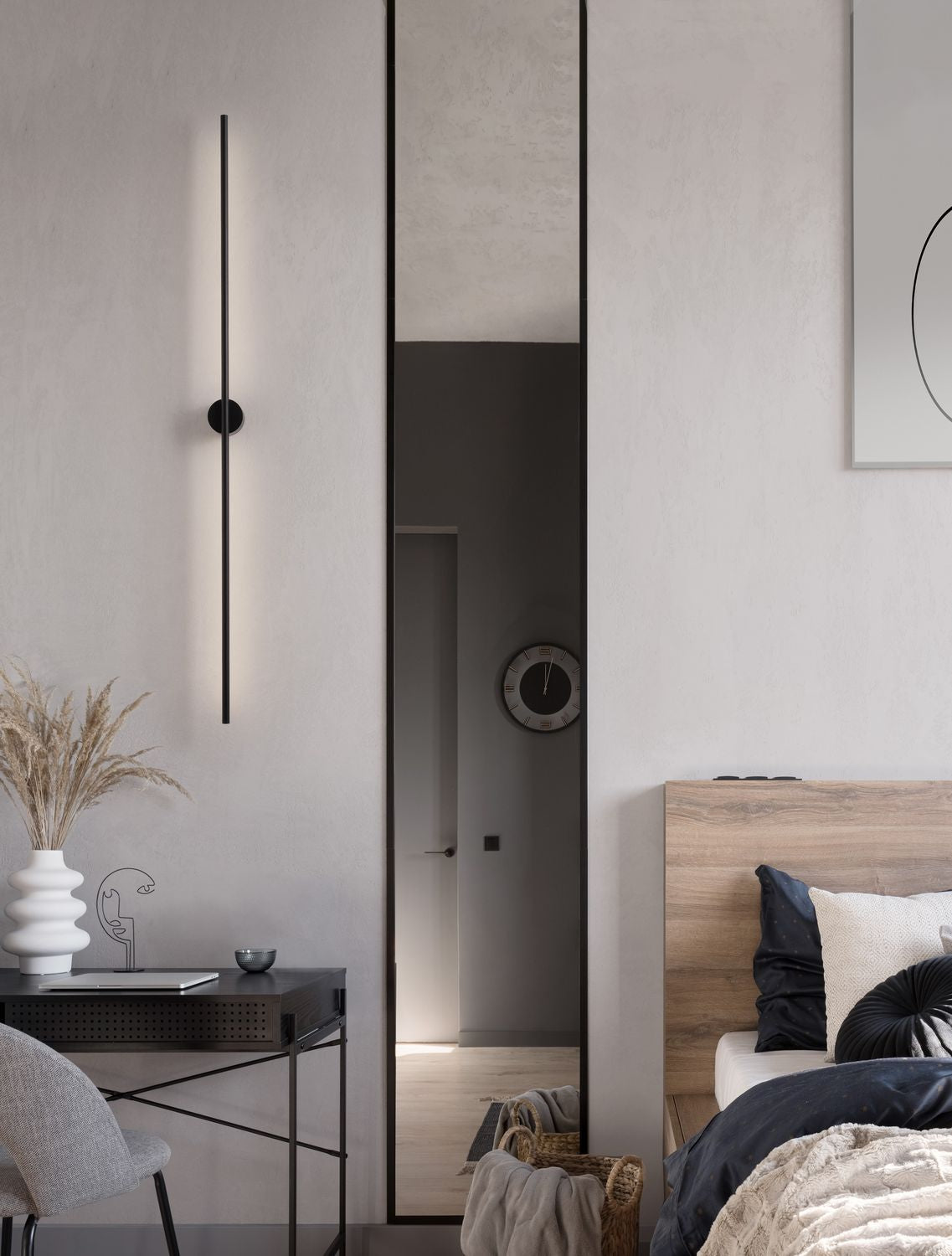 Applique murale noire verticale fixée au-dessus d'un bureau dans une chambre contemporaine