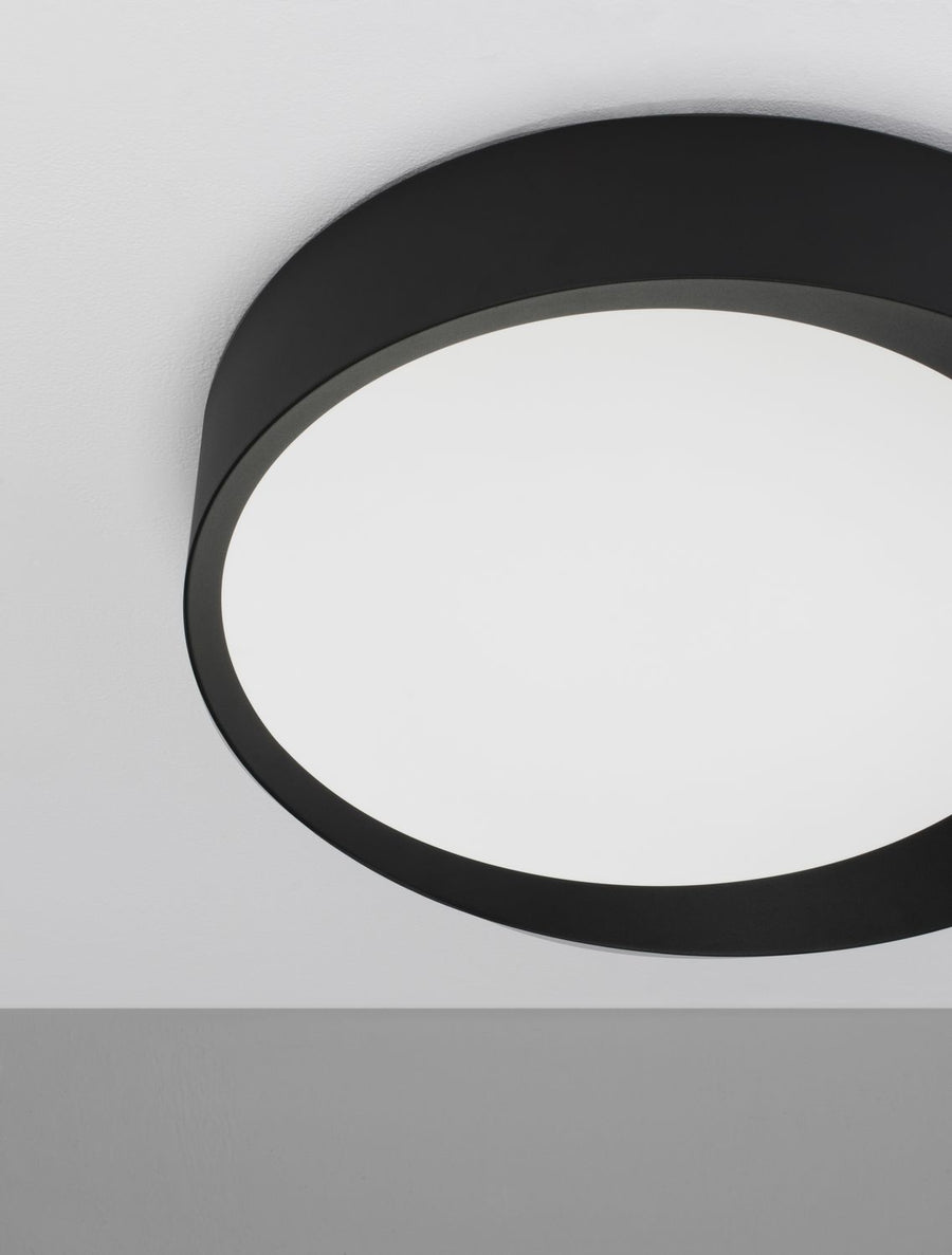 Gros plan sur le cerclage métal noir mat et le diffuseur opalin blanc