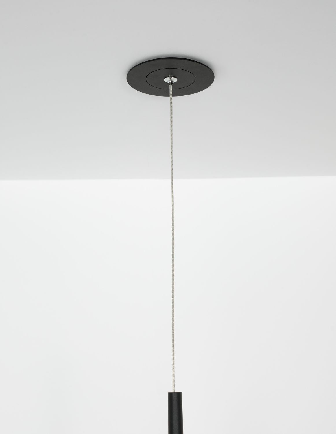 Détail de la rosace ronde noire au plafond et du câble tressé