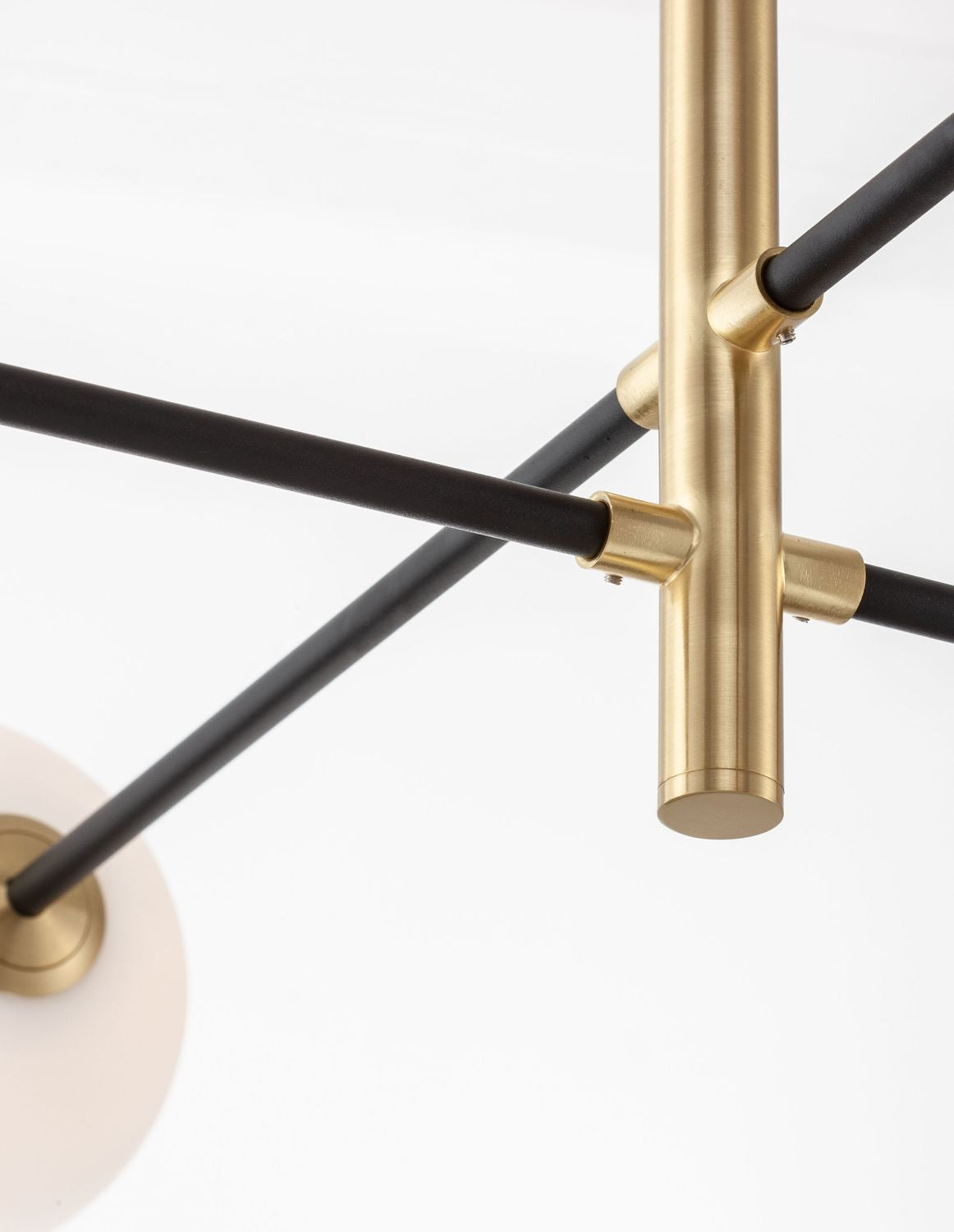 Détail rapproché des raccords dorés et des bras tubulaires noirs de la structure