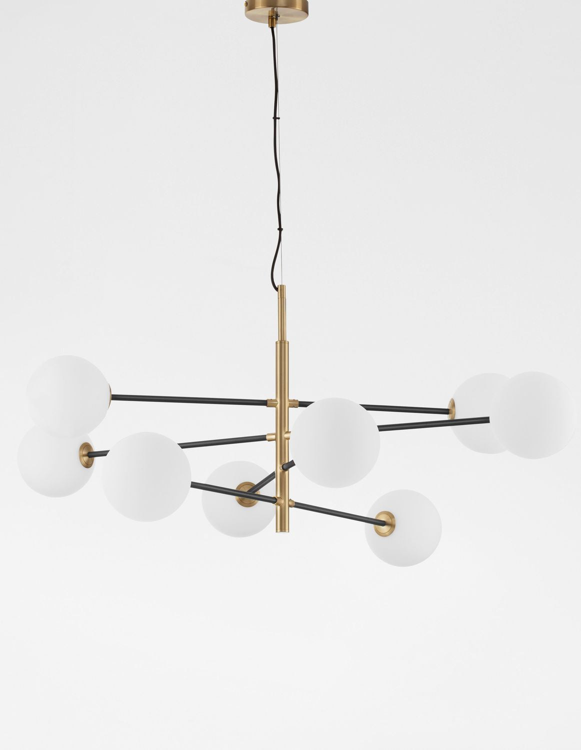 Luminaire présenté de face sur fond clair, structure dorée et globes blancs