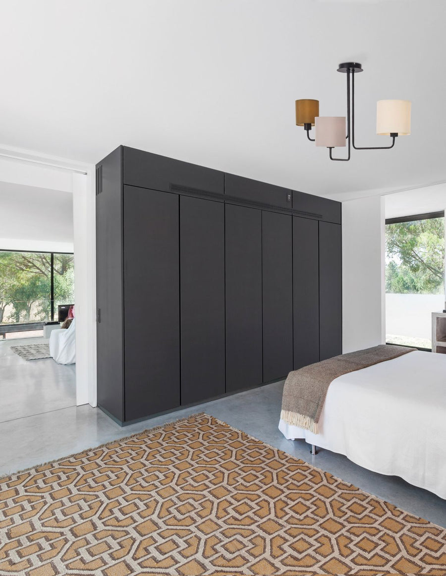 Suspension tricolore au plafond d'une chambre moderne avec armoire noire et tapis