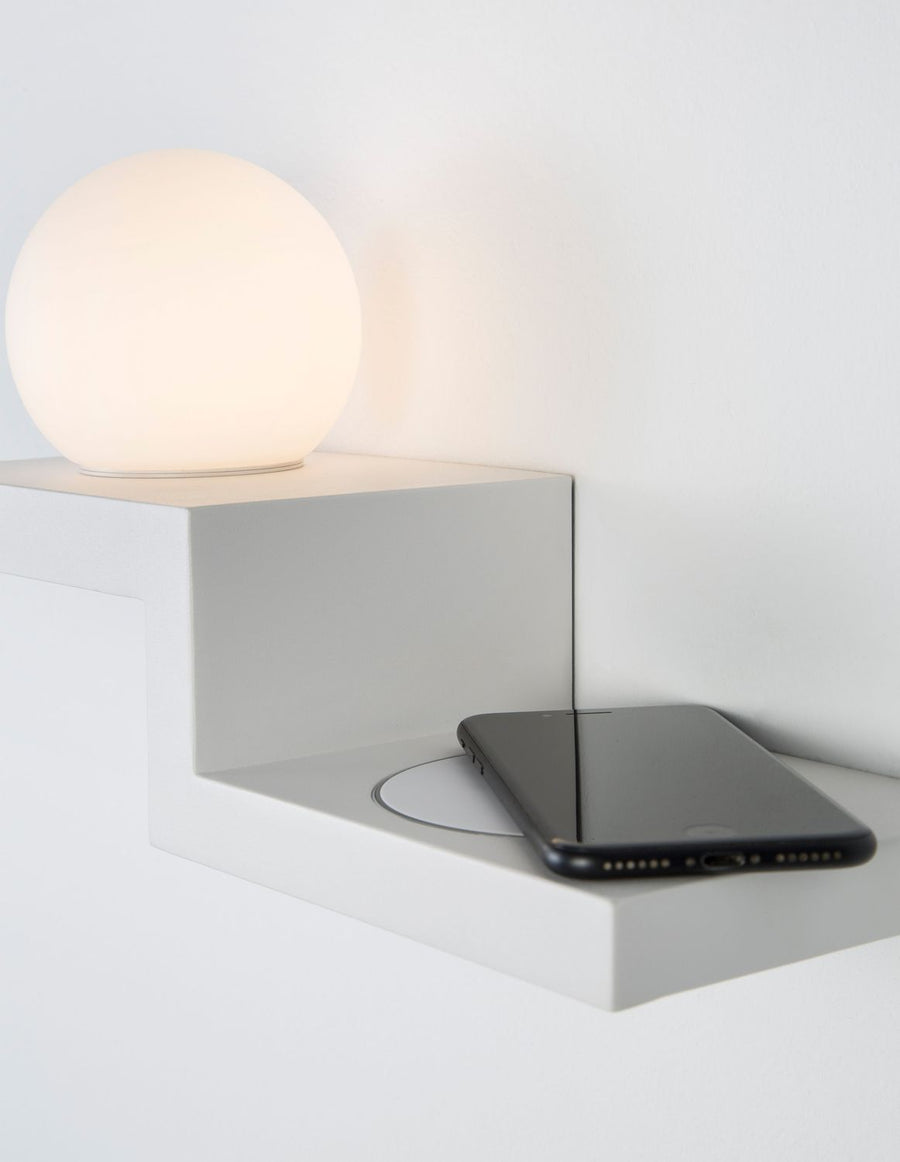 Applique murale blanche allumée, sphère de verre et téléphone en charge sans fil