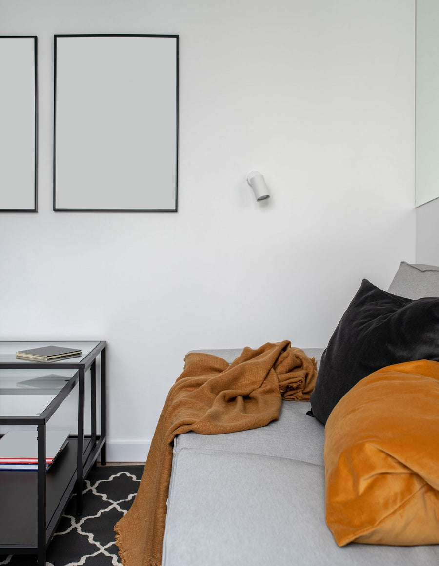 Applique murale blanche installée au-dessus d'un lit dans une chambre claire