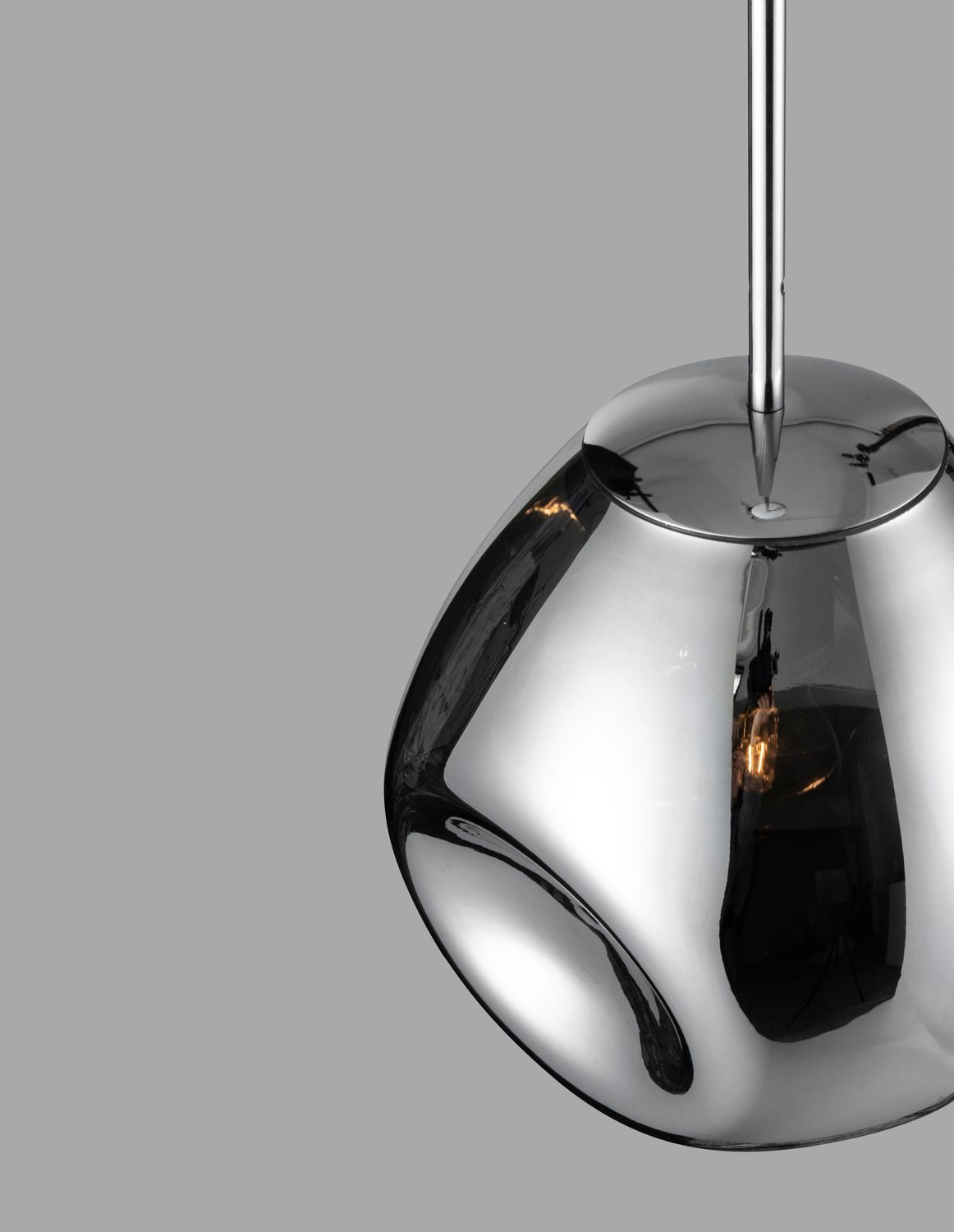 Vue rapprochée de la suspension chromée montrant le verre brillant et ampoule.