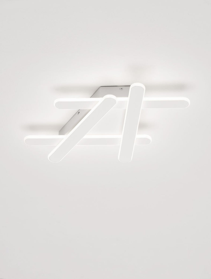 Plafonnier blanc allumé au plafond, lumière diffuse et ombres douces