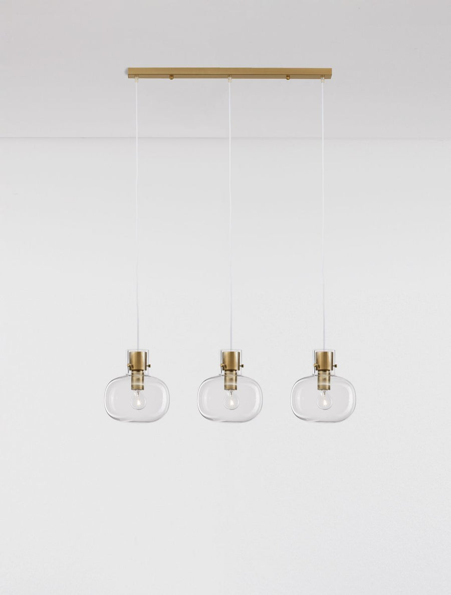 Trois suspensions en verre transparent suspendues sous leur barre de fixation