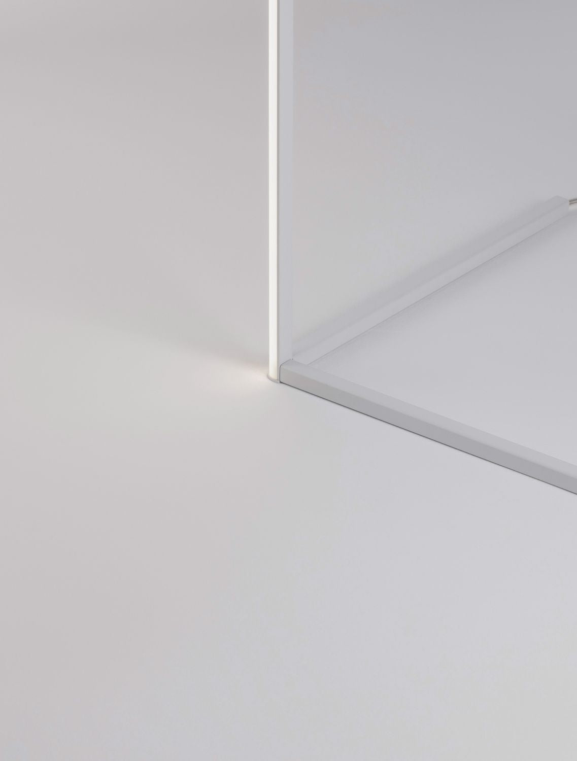 Détail du pied et de la base du lampadaire blanc, lumière au bas de la tige.