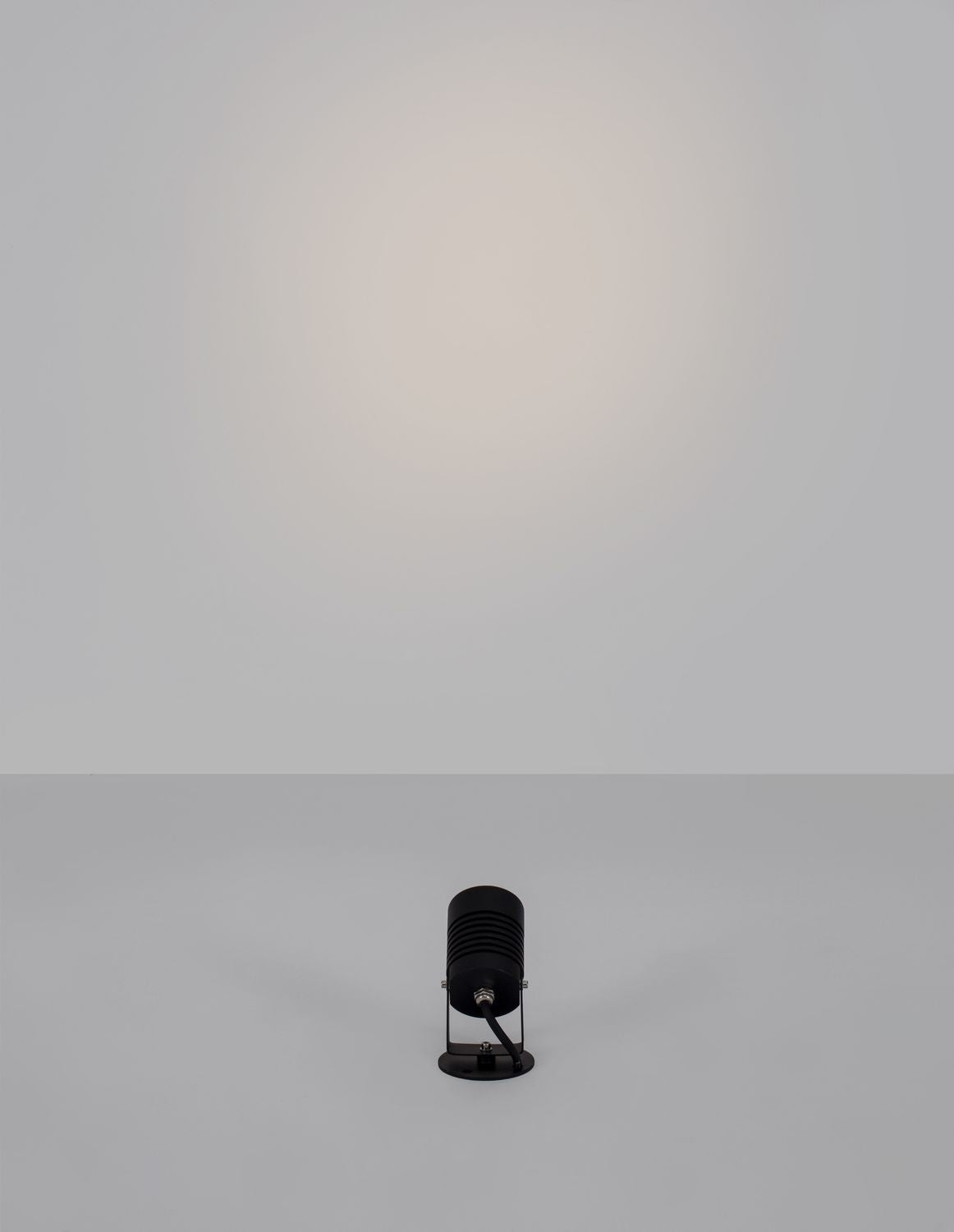 Vue de face en contre-plongée, projecteur orienté vers le haut projetant sa lumière