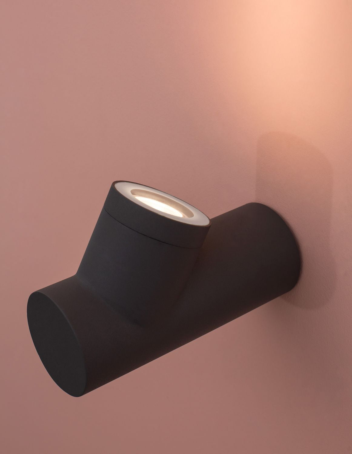Détail de la face éclairée, verre et ampoule visibles dans cylindre orientable noir.