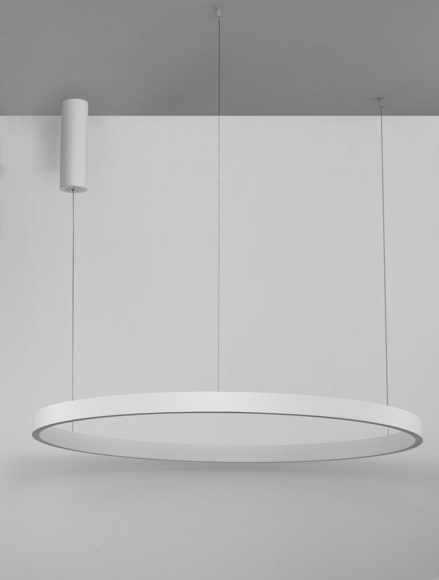 Vue en situation du luminaire suspendu devant un mur gris clair, anneau éteint